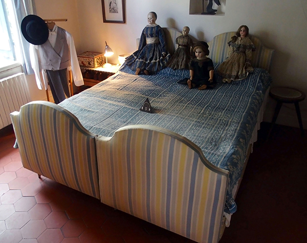 アンティーク人形が置かれた寝室のベッド。