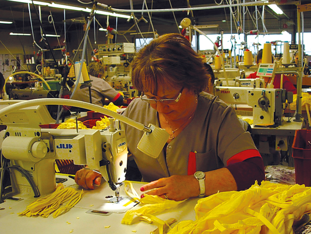3本の紐からなる肩紐を仕上げていく縫製人。