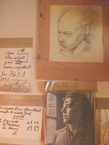 壁に貼られた詩、自画像、ブルトンの写真…